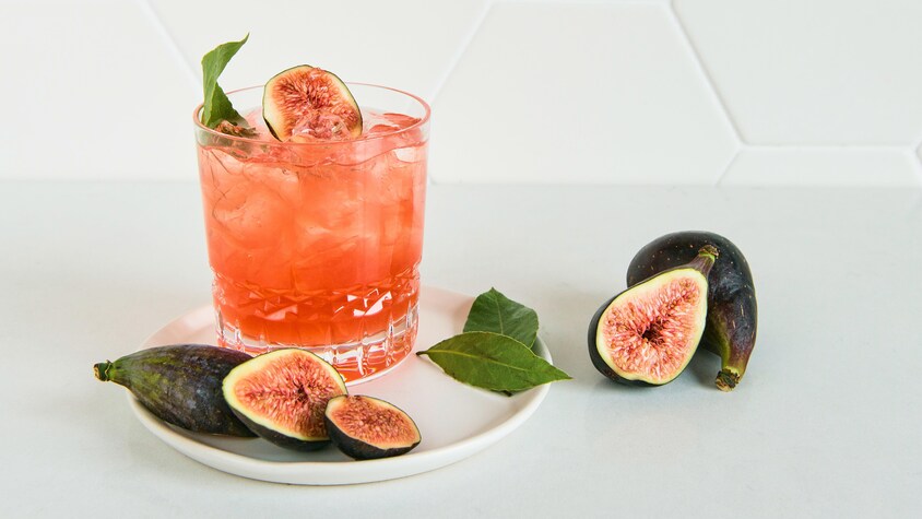 Un cocktail orangé accompagné de figues.
