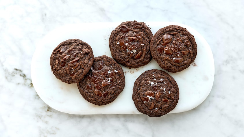 Cinq biscuits double chocolat dans une assiette.