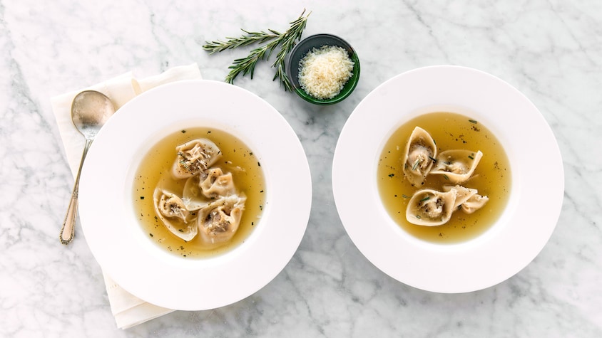 Deux bols de soupe avec quatre tortellinis.