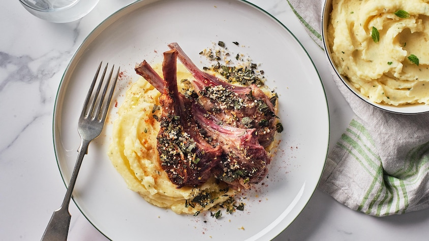 Des côtelettes d'agneau grillées sur de la purée de pommes de terres à la menthe.