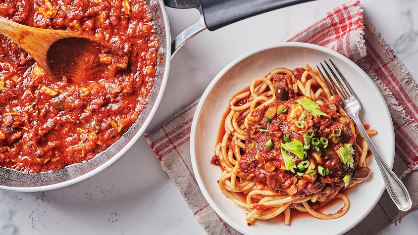 Une assiette remplie de spaghetti à la sauce aux tomates grillées et au thon.