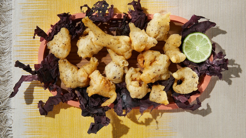 Un bol en terre cuite est rempli de crevettes frites à la tempura.
