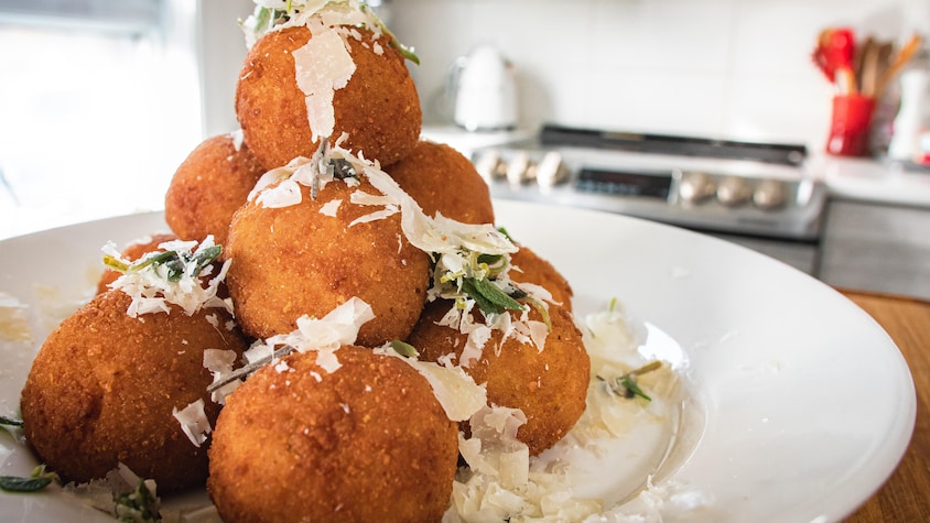 Des arancini à la courge Butternut, sauge et gorgonzola dans une assiette.