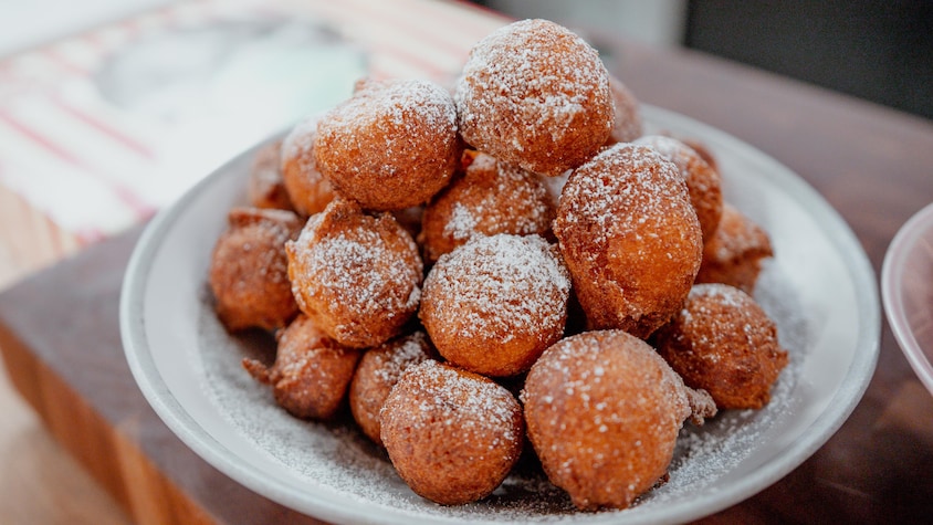 Des beignets à la patate douce dans un bol, saupoudré de sucre blanc. 