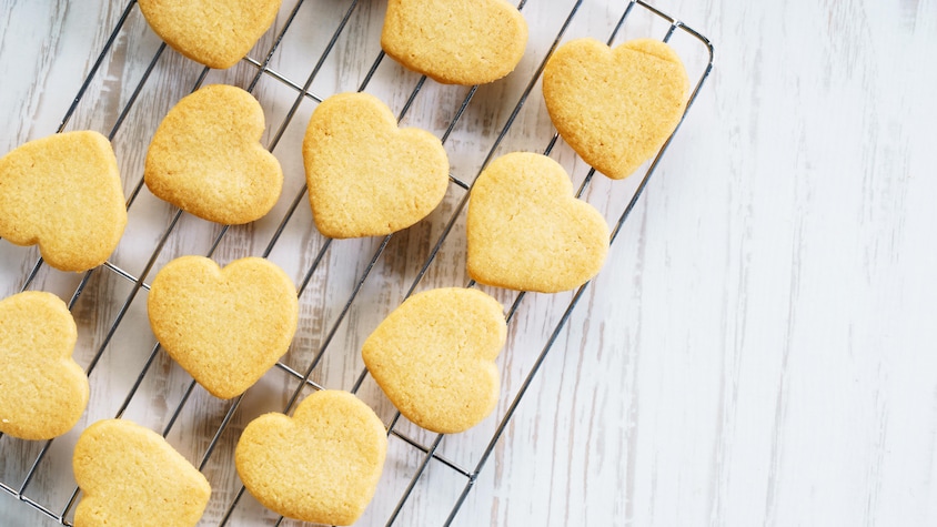 Des biscuits sablés en forme de cœur sur une grille.