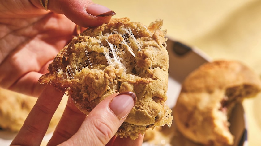 Des mains en train de séparer un biscuit en deux.