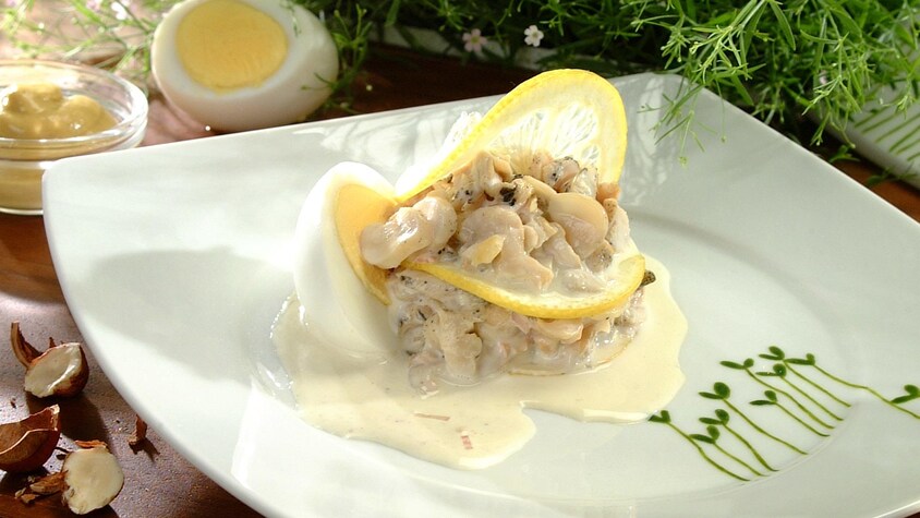 Une assiette avec des buccins en salade et sauce rémoulade.