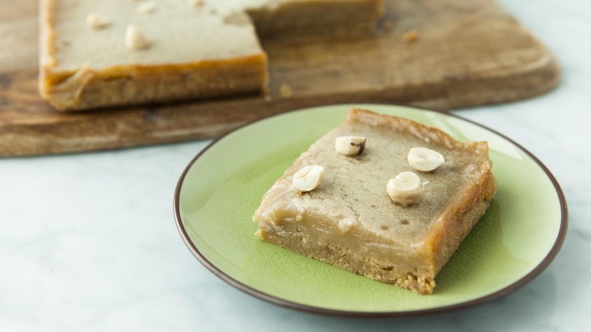 Un carré à l'érable et aux noisettes servi dans une petite assiette à dessert.