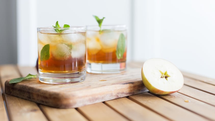 Deux verres remplis d'un cocktail à la pomme avec des feuilles de menthe.