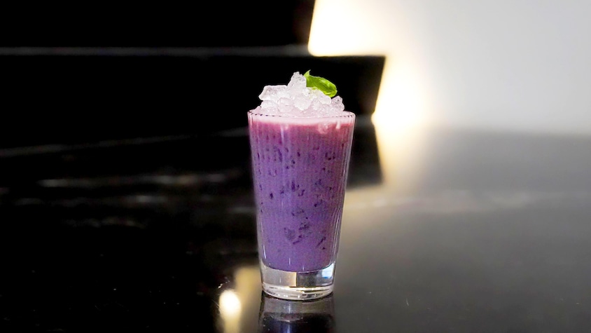 Le cocktail Tiki-toi servi dans un verre rempli de glaçons et garni de basilic.