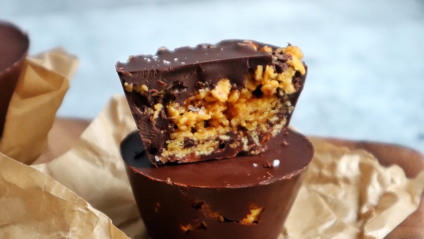 Deux coupelles au chocolat empilées sur un morceau de papier.