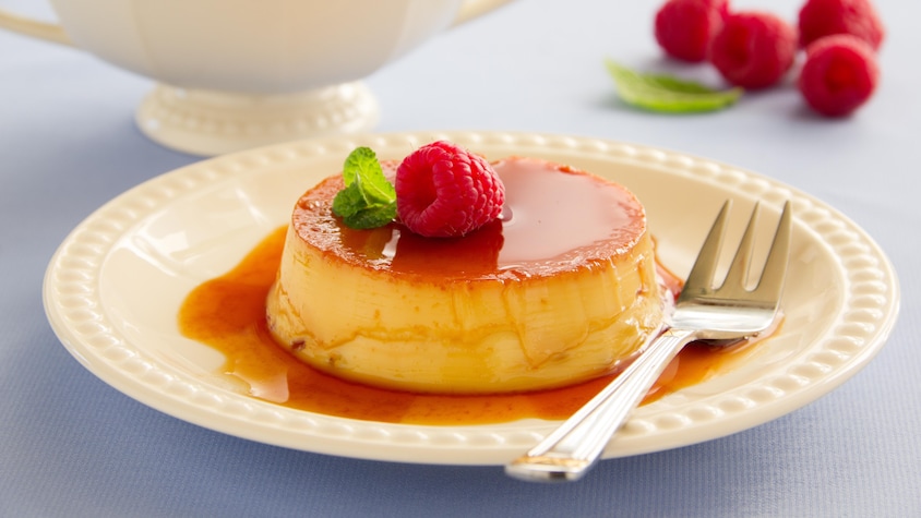 Une crème caramel recouverte de sirop et d'une framboise.