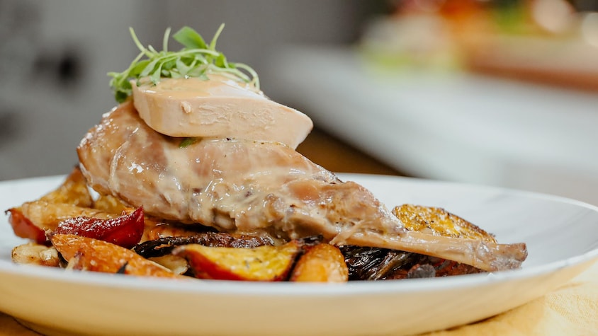 Cuisse de lapin braisée servie sur des pommes de terre et garnie d'une tranche de foie gras.