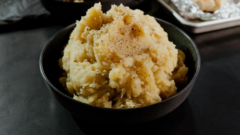 Des pommes de terre à l'ail rôti en purée dans un bol.