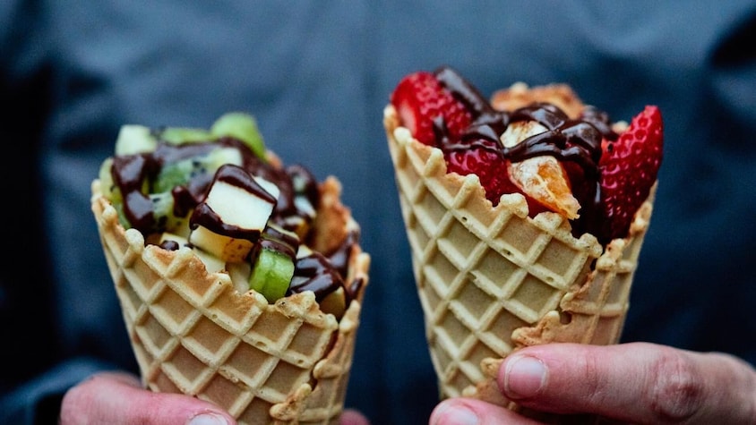 Deux cônes avec des fruits et de la fondue au chocolat.