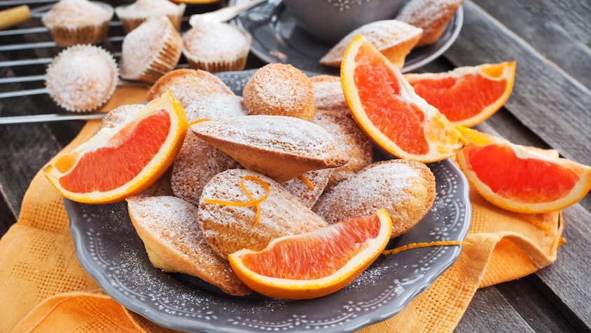 Des madeleines parfumées à l'orange dans une assiette.