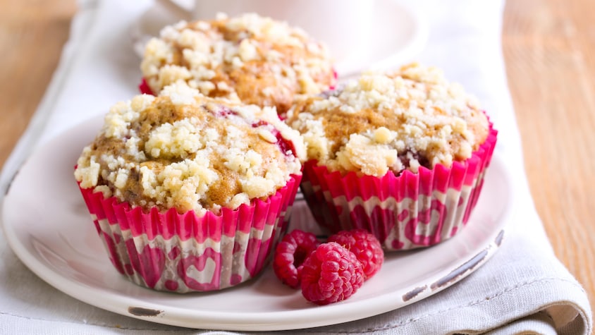 Trois muffins aux petits fruits dans une assiette.