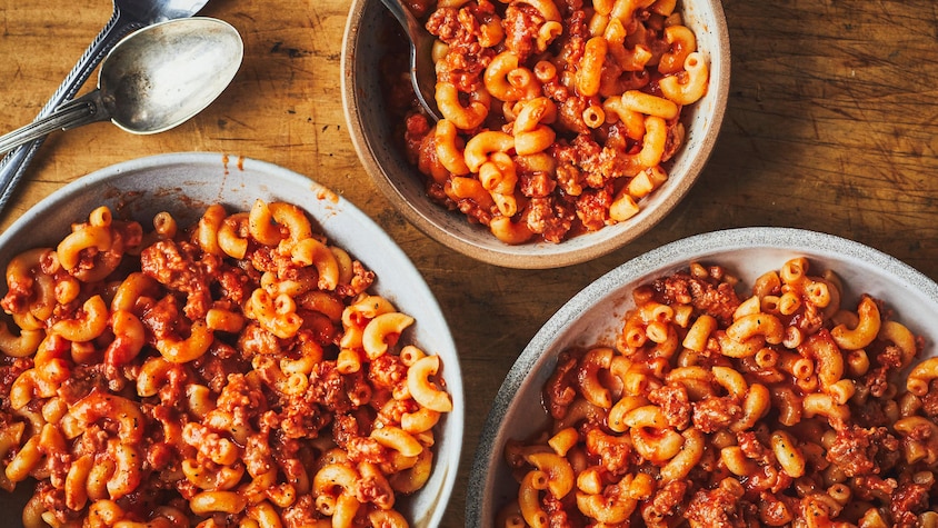 Trois bols de macaroni à la viande sur une table.