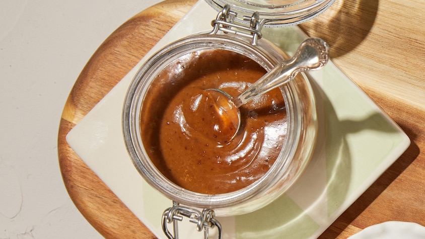 Pot de mayonnaise au miso avec de l'ail noir sur une planche.