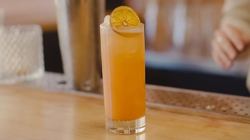 Un verre rempli d'un mocktail orangé.