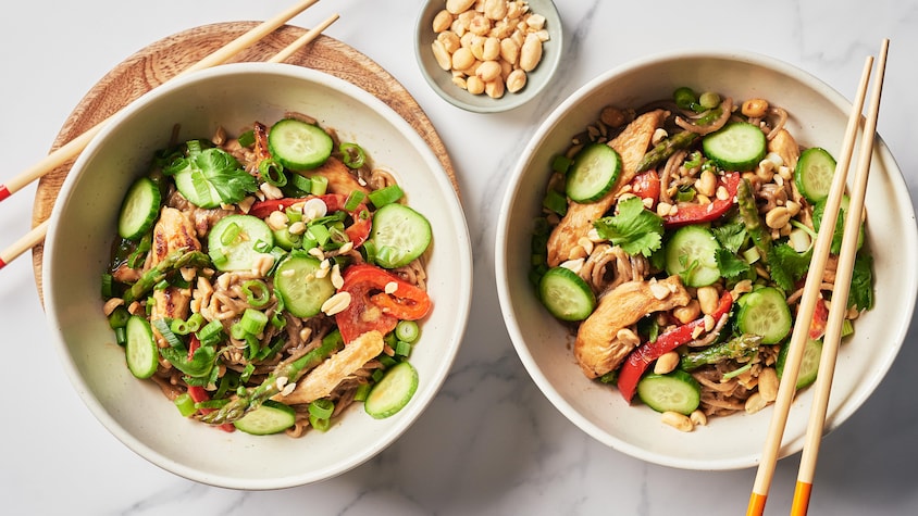 Deux bols de nouilles soba aux arachides et au poulet.