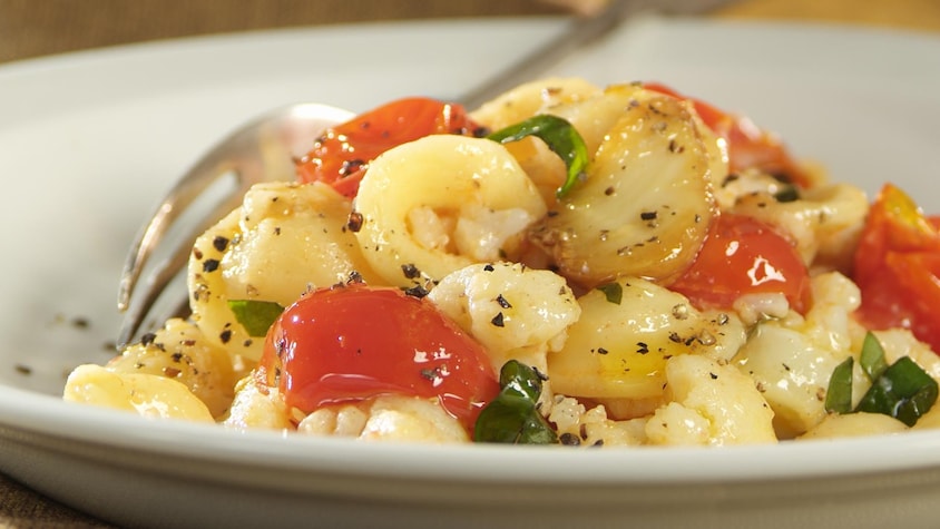 Orecchiettes au chou-fleur et tomates cerises dans une assiette.
