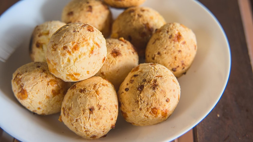 Des petits pains en forme de boules, grillés, dans une assiette creuse.