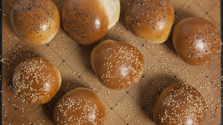Plusieurs pain à hamburger servis sur une plaque de cuisson.