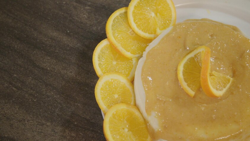 Un dessert avec une purée d'orange et des tranches d'orange dans une assiette.