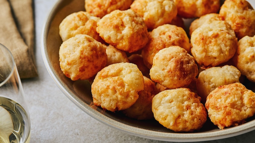 Un bol contenant les petits pains au fromage brésiliens sur un comptoir. 