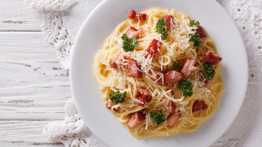 Une assiette remplie de pâtes carbonara.