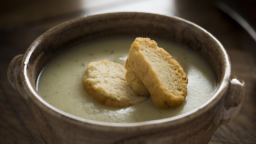 Un bol rempli de potage avec trois croûtons sur le dessus.