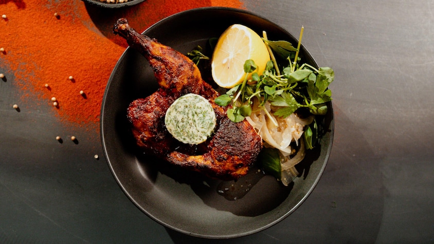 Un morceau de poulet avec une rondelle de beurre aux herbes. 