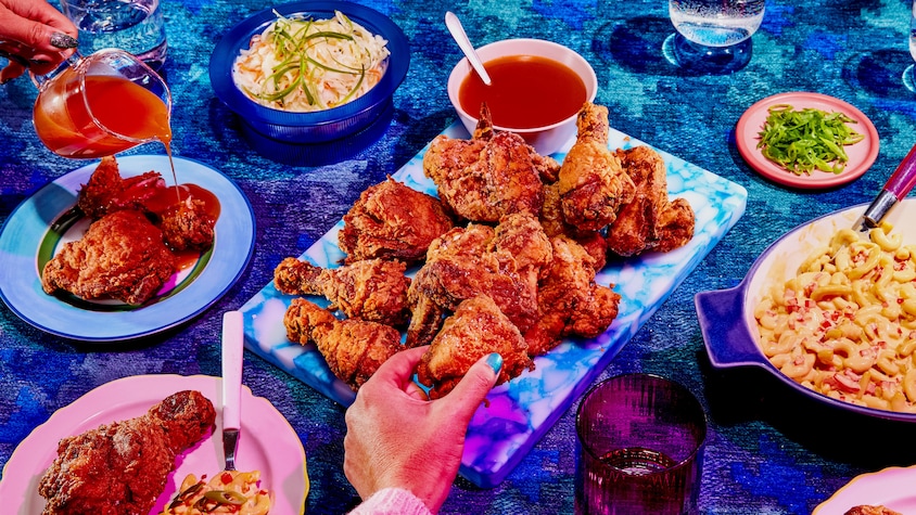 Un plat au centre de la table rempli de poulet frit. 