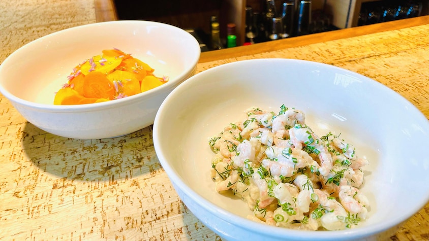 Un bol de salade de crevettes nordiques et un autre qui contient des carottes marinées.