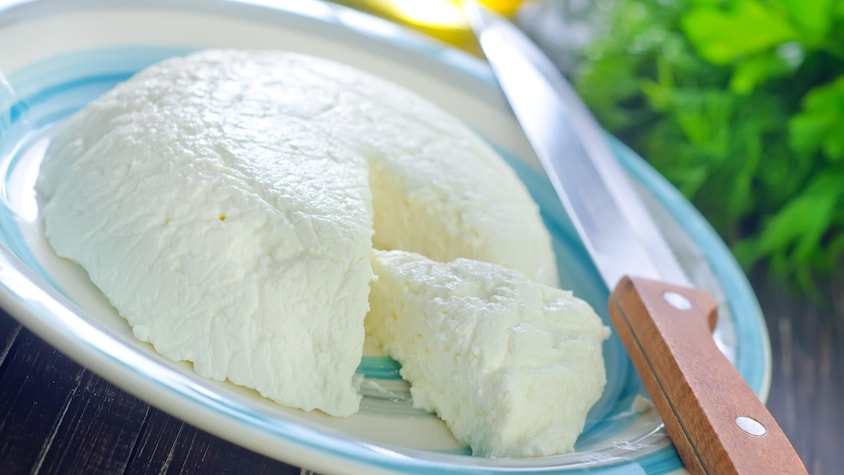 Un fromage blanc, rond et une pointe coupée. 