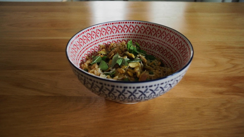 Un bol de risotto, du basilic et des pistaches.