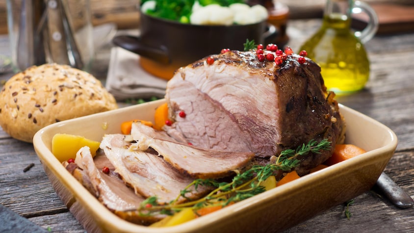 Un rôti de porc avec des légumes sortant du four.