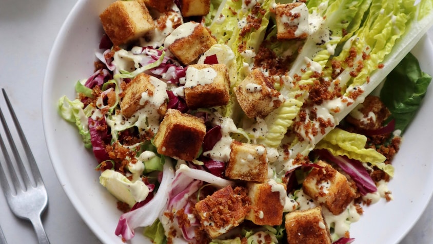 Un bol de salade César végane, garnie de croûtons de tofu.