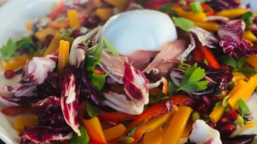 Une salade colorée de laitues, légumes et fromage burrata.