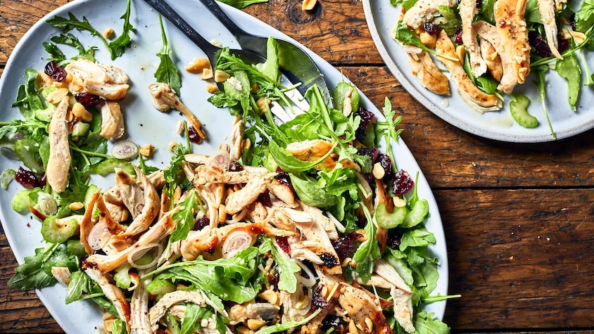 Salade de roquette au poulet et aux canneberges dans une assiette.