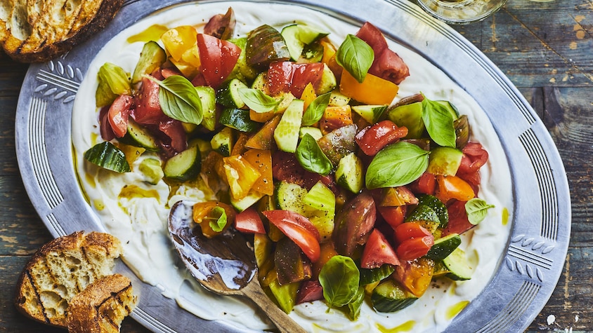 Salade de tomates à la ricotta fouettée dans une grande assiette de service.