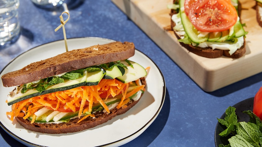 Sandwich au labneh, menthe fraiche et légumes croquants dans une assiette.