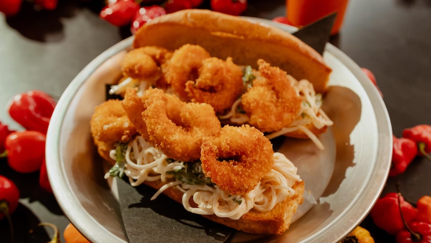 Un sandwich po boy aux crevettes et au céleri-rave dans une assiette.