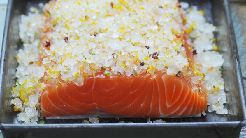 Un filet de saumon recouvert de sel pour en faire un gravlax.