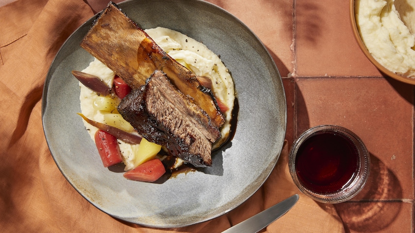Un morceau de côte de bœuf sur un monticule de purée de pommes de terre.