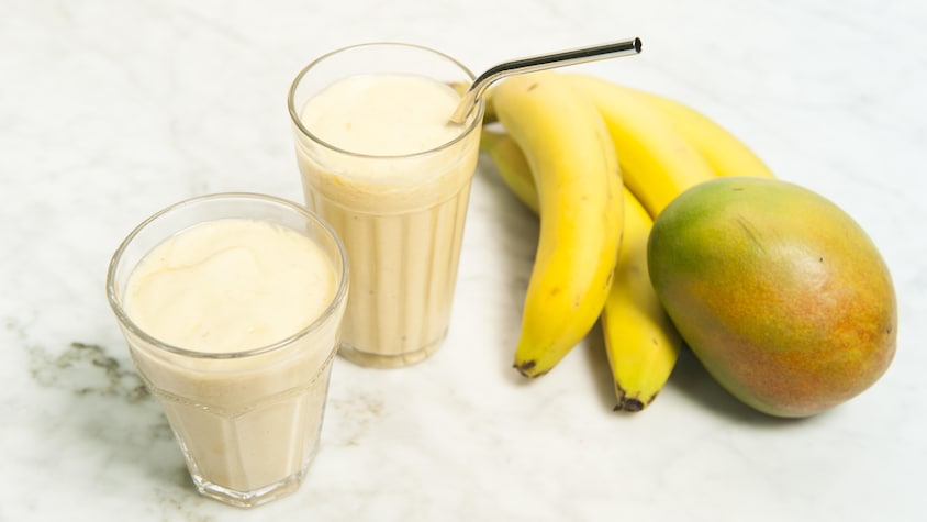 Deux verres de smoothie à la mangue et la banane.