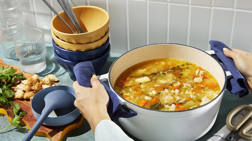 Une casserole contenant de la soupe poulet et riz.