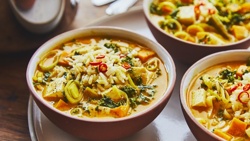 Soupe-repas végé au cari thaï et au poireau dans trois bols.