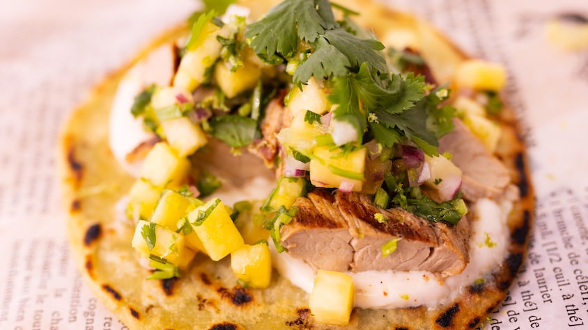 Zoom sur un tacos au filet de porc au chili et à la coriandre.